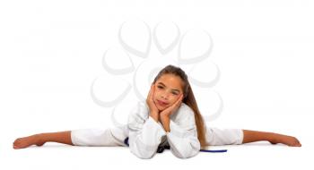 little karate girl in a white kimono and a blue belt sits for a workout in sports twine