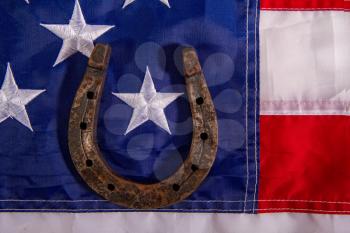 Horseshoe symbol of good luck lies on the stars of the American flag