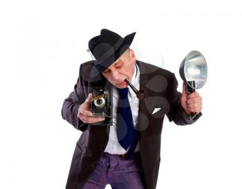 adult news photographer in a costume of the last century fashion and a wide-brimmed hat with an old camera and flash diligently takes a photo.
