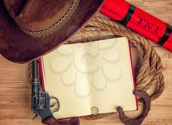 conceptual photo - open book with empty space telling about cowboys and the wild west on a wooden table