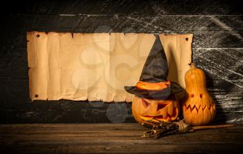 Blank manuscript with place for text witch's broom flying hat and two pumpkins on dark background