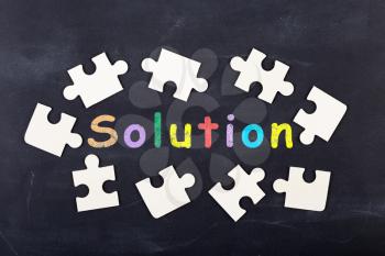 Business Solution concept - inscription and jigsaw blocks on the blackboard