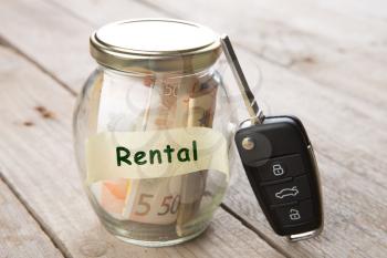 Car rent concept - money glass , car key and roadmap