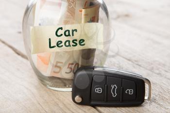 Car finance concept - money glass with words Car lease, car key