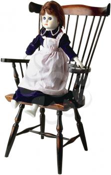 Royalty Free Photo of a Doll Sitting in a Wooden Children's Chair