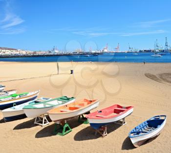 Beach with old boats and big port at Las Palmas, Gran Canaria.