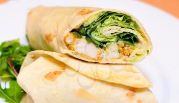 Tortilla wraps with chicken nuggets, fresh vegetable and salad.