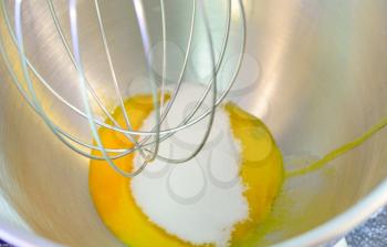 Preparing egg yolk with sugar in kitchen mixer.