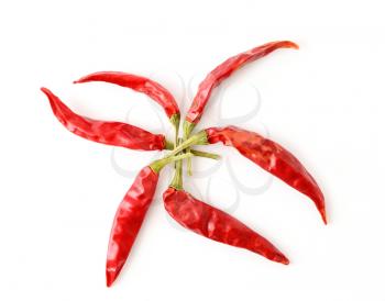 Top view of dried red hot chilli peppers arranged in a star shape on white background.
