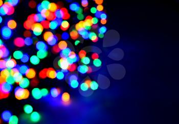 Blurred glittering christmas LED multi color lights, circle color bokeh on dark background.