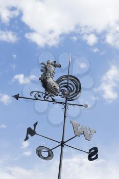 Rooster Weathervane Against Blue Sky and Clouds