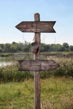 Wooden Arrow Sign at the Lake in Nature