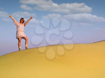 beautiful woman with thumbs up standing on desert dune