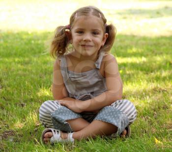 little girl sitting on grass 