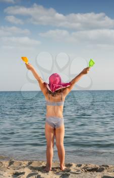 happy little with hands up on beach summer scene