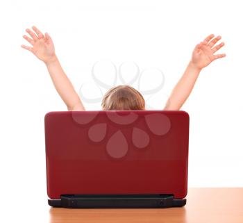 happy little girl raised his hands behind laptop