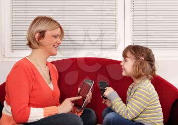mother and daughter with tablet and smart phone