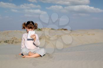 little girl with tablet pc in desert