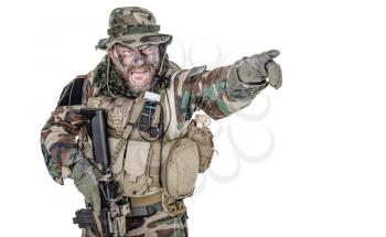 United States Commando half length studio shot. Mouth opened, soldier yelling, emitting intiminate formidable frightening scream pointing finger target and giving attack direction to subordinates