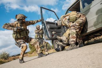 Squad of elite french paratroopers of 1st Marine Infantry Parachute Regiment RPIMA detaining terrorist in the car, low angle view