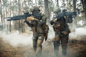 Norwegian Rapid reaction special forces FSK soldiers in field uniforms in action in the forest fog covering each other