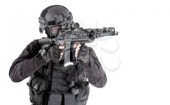 Police special forces, SWAT team fighter in tactical ammunition and armor, aiming weapon, observing suspect movements, controlling sector with optical sight on service rifle isolated studio shoot