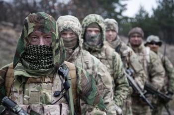 Army elite forces tactical group soldiers, skilled commandos squad, members wearing camouflage uniform, hiding faces behind masks, standing in line behind commander