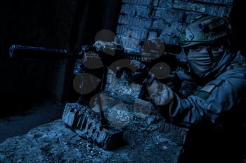 Marksman in action in the ruined city under cover of darkness