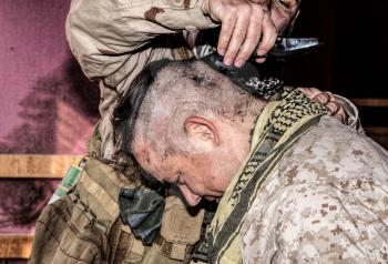 Soldier cuts comrades hair with trimmer. United States marine shaving friends head with clipper in combat conditions. Recruiter preparing for service in military forces by receiving initial haircut