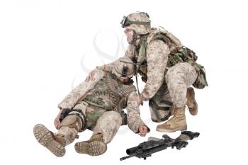 Military medic, commando shaking for shoulders, trying bring to consciousness, checking condition of unconscious, wounded soldier or comrade, isolated on white. Injured, dying infantryman rescue