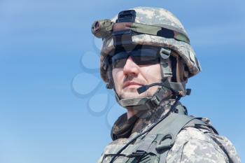 Portrait of United states airborne infantry man, camouflage uniforms dress. Combat helmet, tactical light, headphones, radio microphone on his mouth
