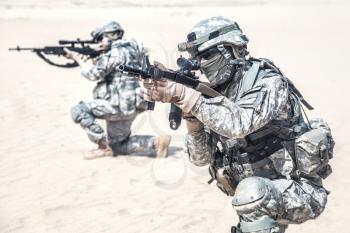 Team of United states airborne infantry men in action in the desert, cropped view