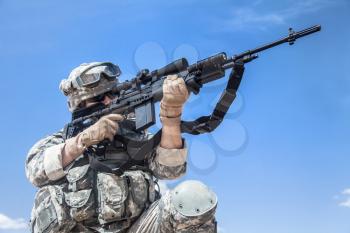 United states airborne infantry marksman in action in the desert, pointing the enemy. High accuracy firing concept