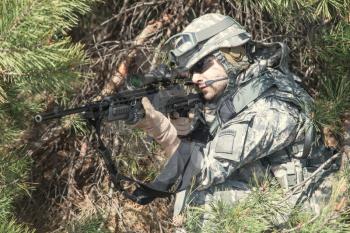 United states airborne infantry marksman in action in the forest, pointing the enemy. High accuracy firing concept