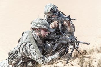 Team of United states airborne infantry men in action in the desert, cropped