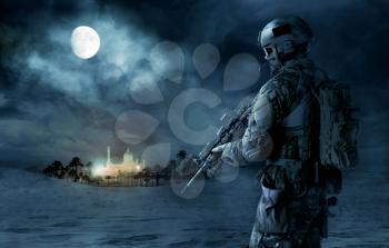Green Berets US Army Special Forces soldier patrolling desert. Cloudy night, full moon, oasis palace