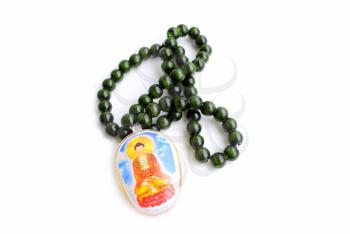 Green Chinese beads with medallion on white background.