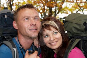 Young tourist couple in the autumn park with rucksacks