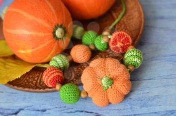 Necklace made of knitted beads for a child sitting in sling. Composition of decorative pumpkins.