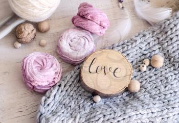 Homemade pink berry marshmallow. Composition with the inscription Love, wooden and knitted elements.