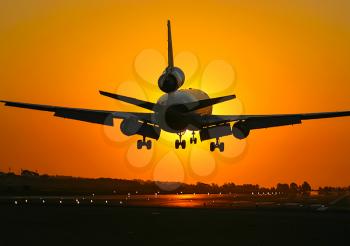Takeoff of a passenger plane on the background of a sunset. Flight of the air liner at sunset.