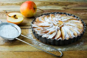 Homemade apple pie, fruit dessert, tart, apples and caster sugar on the wooden table, selective focus