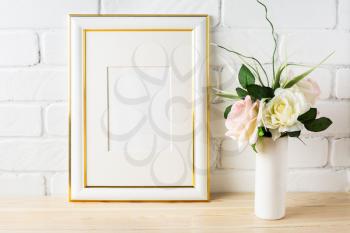 White frame mockup with pale pink roses in vase. Portrait or poster white frame mockup. Empty white frame mockup for presentation artwork.