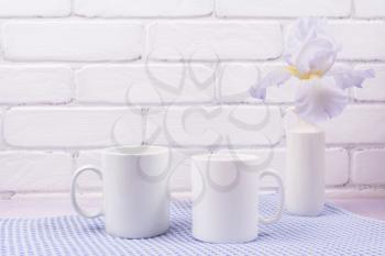 Two white coffee  mug mockup with pale lavender color iris flowers.  Empty mug mock up for design promotion.   