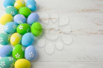 Colored Easter eggs on a wooden white background, copy space