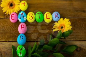 Easter eggs and gerbera, daisy on a dark wooden background. Easter background. Easter eggs. Easter. Easter symbol.  Easter card. Easter greetings. Happy Easter. Copy space