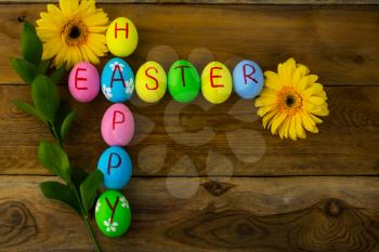 Easter eggs and yellow flowers on a dark wooden background. Easter background. Easter eggs. Easter. Easter symbol.  Easter card. Easter greetings. Happy Easter. Copy space