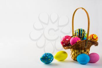 Colored Easter eggs in the basket on a white background. Easter background. Easter background. Easter symbol. Copy space