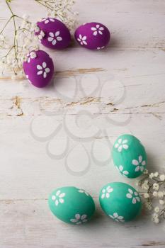 Pale turquoise and Pink Decorated Easter eggs on a white wooden background, vertical, space for text, copy space