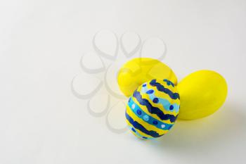 Yellow hand- decorated Easter eggs with abstract design on a white background. Easter background. Easter symbol. Copy space